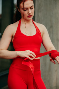 Midsection of woman holding red while standing outdoors