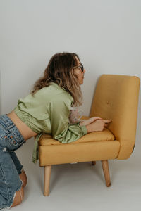 Young woman sitting on sofa at home - dreamy photoshoot