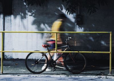 Blurred motion of man riding bicycle on road