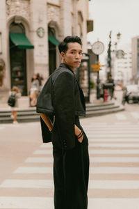 Portrait of young man standing in city