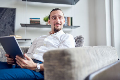 Young businessman holding digital tablet at home