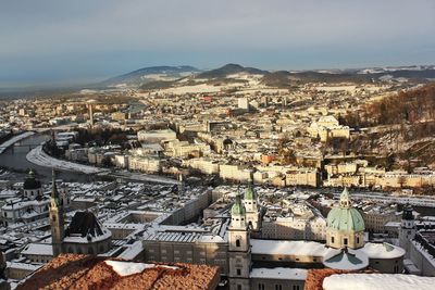 High angle view of snow covered karlskirche by buildings