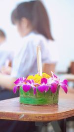 Close-up of hand holding ice cream cone on table