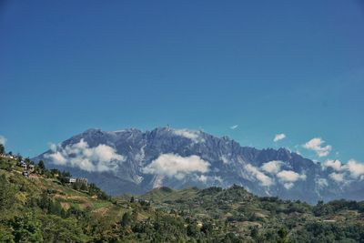 Scenic view of mountains against blue sky