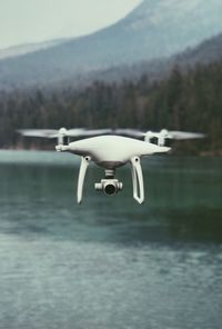 Close-up of drone flying over lake