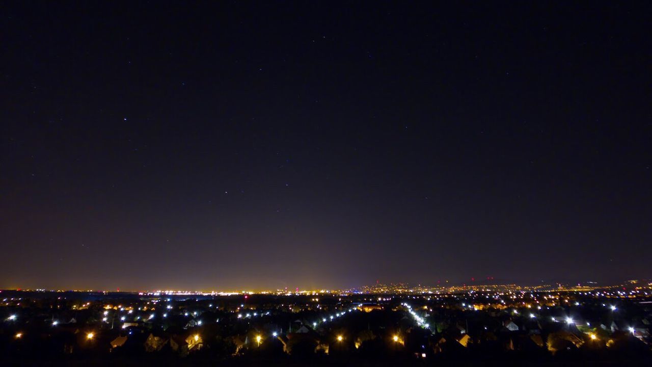 ILLUMINATED CITYSCAPE AGAINST SKY