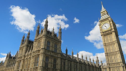 Low angle view of big ben against cloudy sky in city