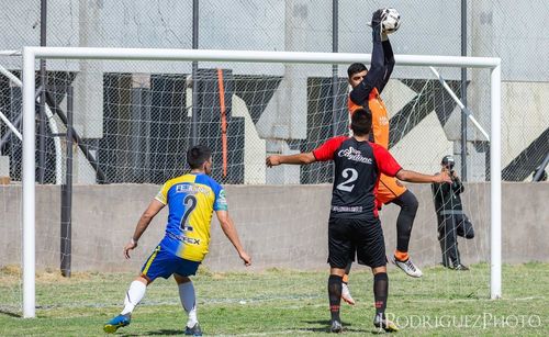 Full length of man playing soccer ball on field