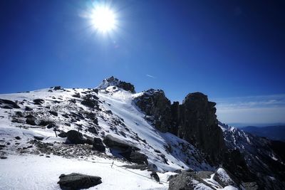 Scenic view of snowcapped mountains against sky on sunny day