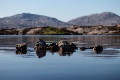 Scenic view of rocks in lake against sky