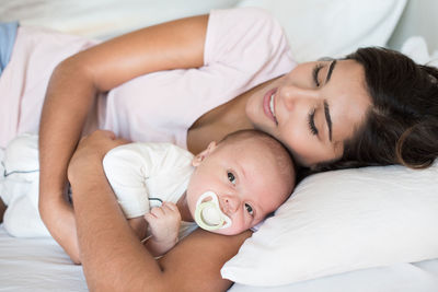 Close-up of mother and son lying down on bed at home