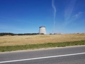 Built structure on landscape against blue sky