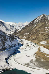 Scenic view of snowcapped mountains against blue sky