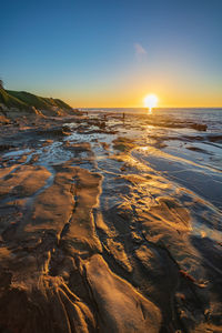 Scenic view of sea against clear sky during sunset