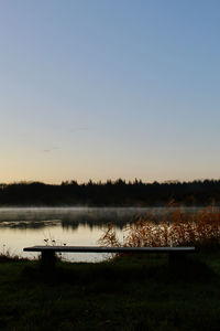 Scenic view of lake against clear sky during sunset