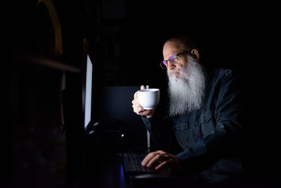 Midsection of man drinking coffee at home