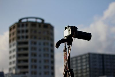 Camera in city against sky
