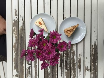 High angle view of carrot cake in plates by flowers on table
