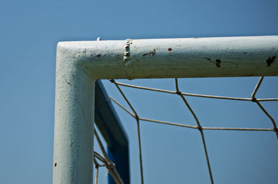 Low angle view of rusty metal against clear blue sky