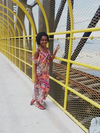 Portrait of smiling teenage girl standing on covered footbridge
