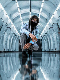 Man crouching on glass floor