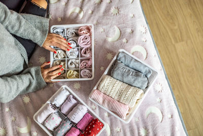 High angle view of woman putting clothes in container