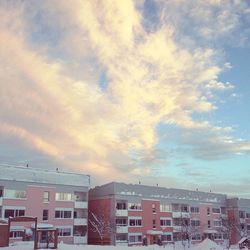 Buildings in city against cloudy sky