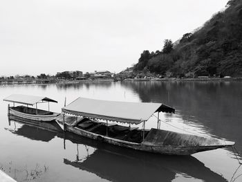 Boats moored at harbor against sky