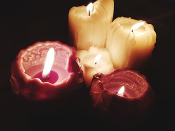 Close-up of lit candles in darkroom