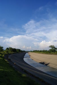 Country road against cloudy sky