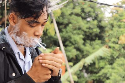 Close-up of man smoking cigarette outdoors