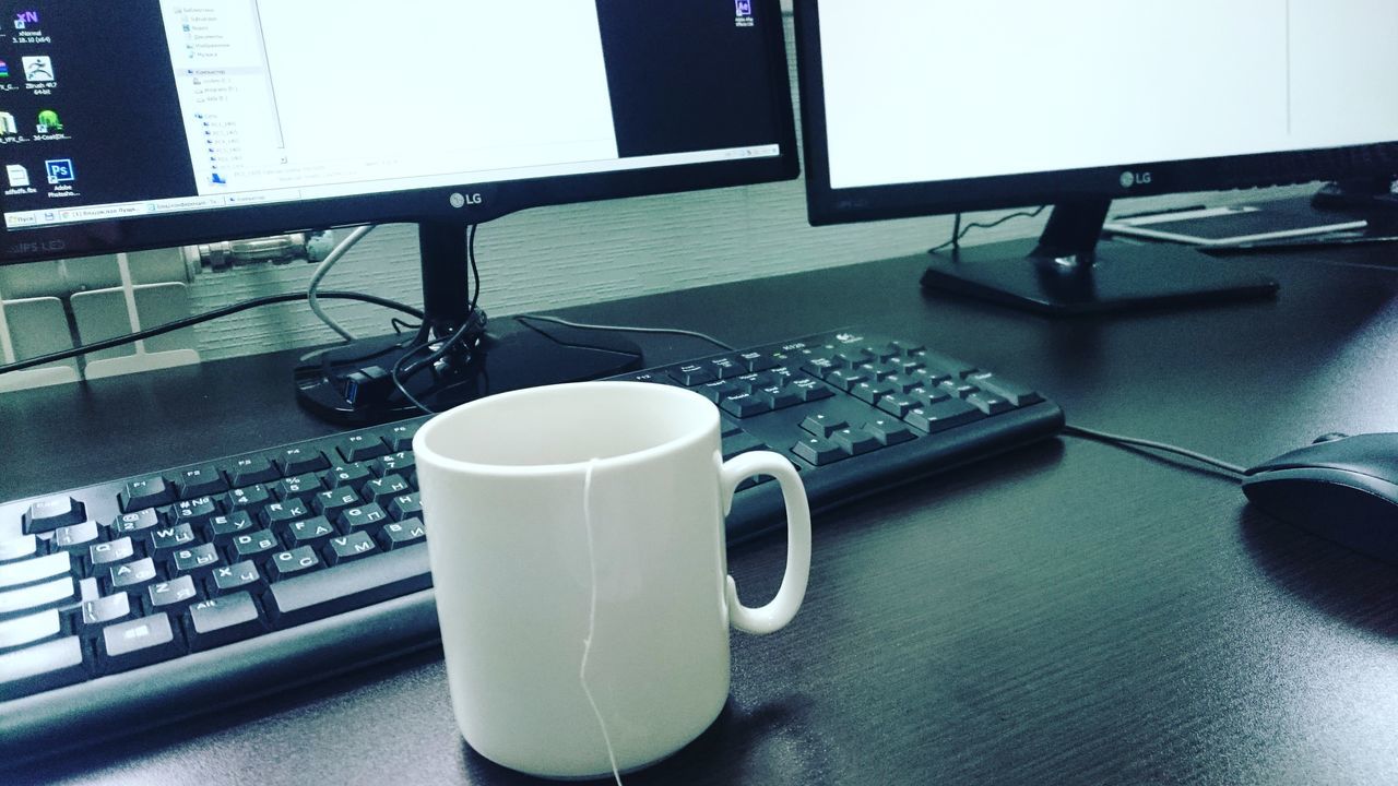 CLOSE-UP OF COFFEE CUP ON TABLE WITH BLACK BACKGROUND