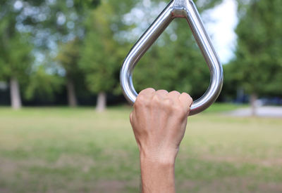 Cropped image of hand holding handle at park