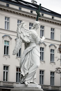 Low angle view of statue against building in city