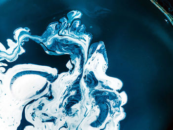 Close-up of water splashing against blue background