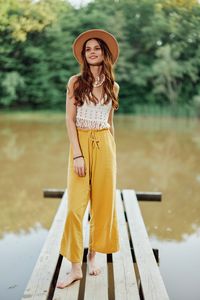 Portrait of young woman wearing hat standing outdoors