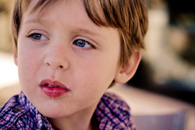 Up close of blue eyed boy looking away to the side