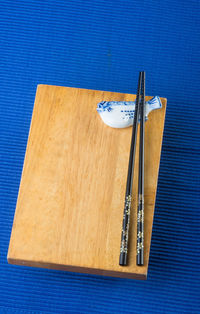 High angle view of chopsticks on wood at table