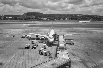 Airplane on airport runway against sky