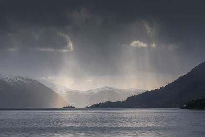 Scenic view of sea and mountains against sky