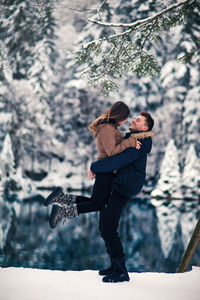 Full length of mother and woman standing on snow