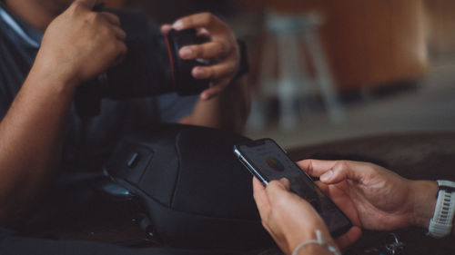 Midsection of man using mobile phone