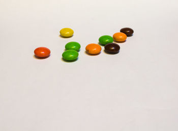 High angle view of multi colored candies against white background