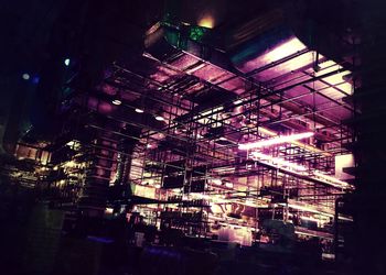 Low angle view of illuminated lights against sky at night