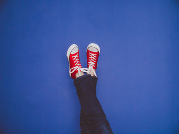 Low section of person against blue background