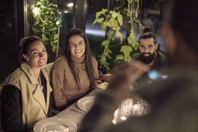 Happy friends having evening meal together