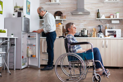 Man and woman standing on table at home