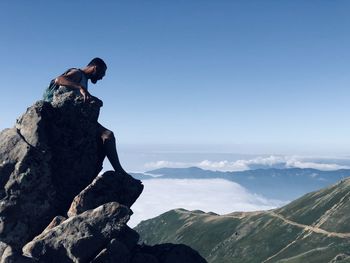 Man on rock against sky