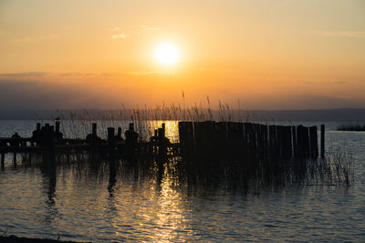 Silhouette of sailboats on sea against sky during sunset