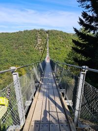 Panoramic view of footbridge amidst trees against sky